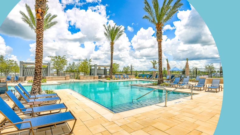 Palm trees and lounge chairs surrounding the outdoor pool at Gatherings of Lake Nona in Orlando, Florida.