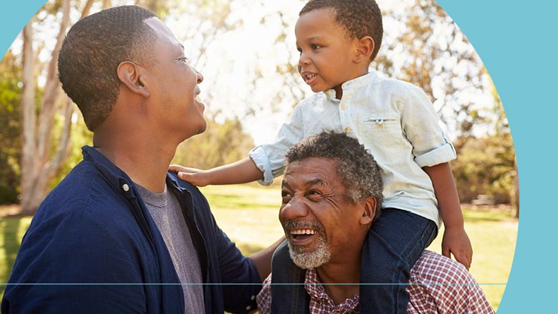 A grandfather with his son and grandson having fun in a park.