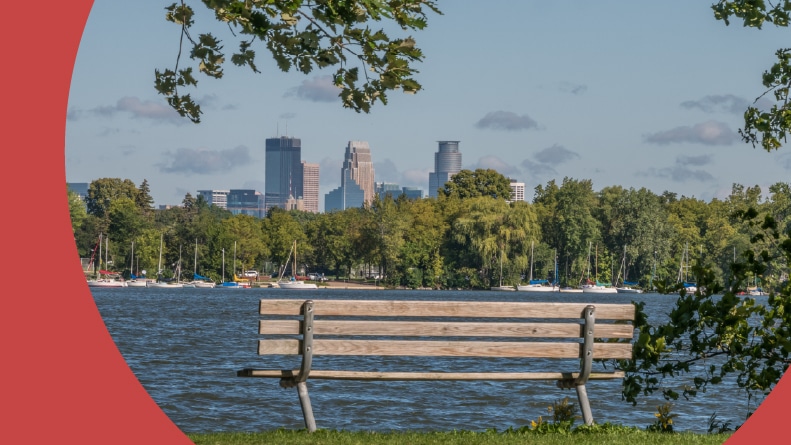 The Minneapolis cityscape as seen from a bench on the opposite side of one of the lakes in the area.
