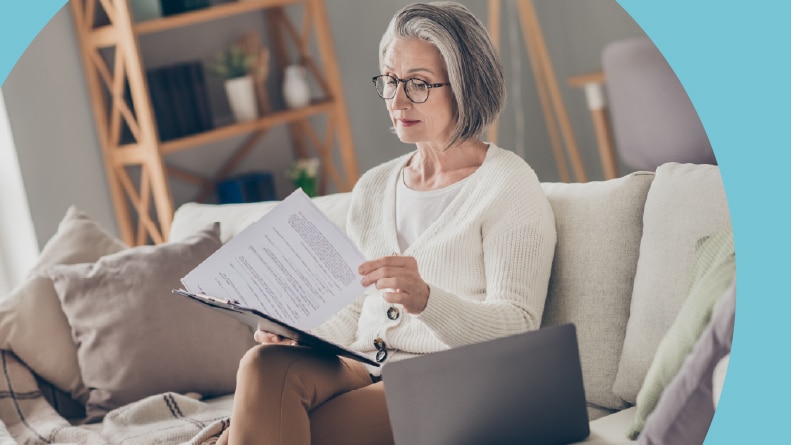A 55+ woman looking over the sale offers for her home.