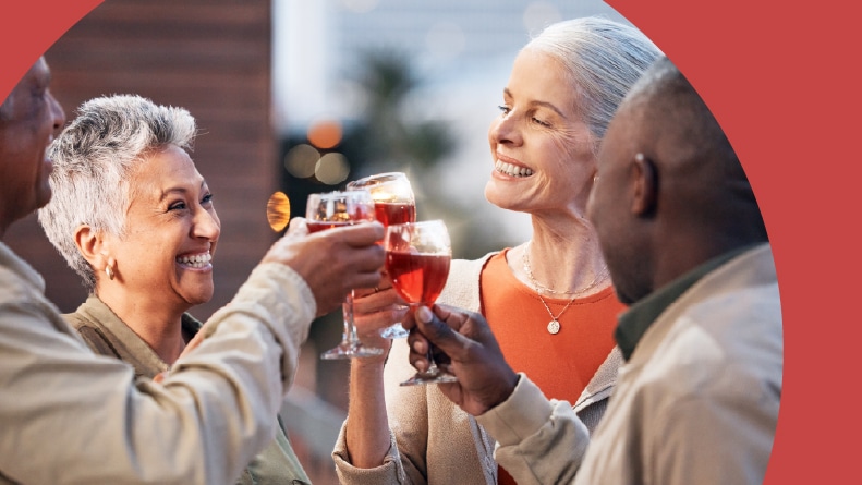 55+ friends toasting with glasses of wine.