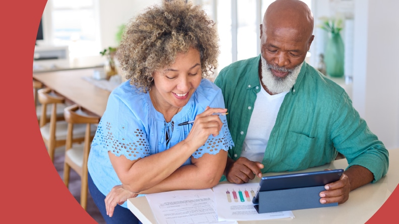 A happy 55+ couple working on their finances to buy a house.