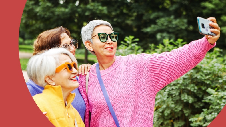 Three 55+ friends taking a selfie together.