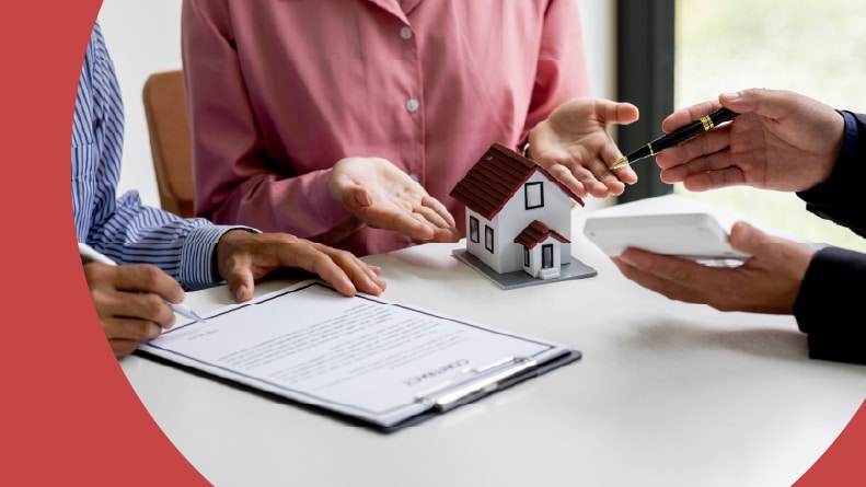 A 55+ homebuying couple signing a contract with a real estate agent.