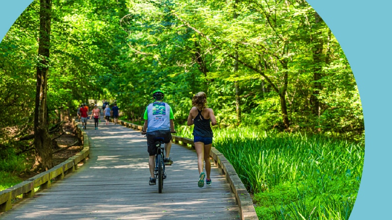Runners and cyclists on a boardwalk that's part of the Big Creek Greenway spanning two counties north of Atlanta.