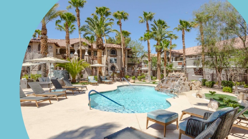 Lounge chairs and palm trees surrounding the outdoor pool at Destinations Pueblo in Las Vegas, Nevada.
