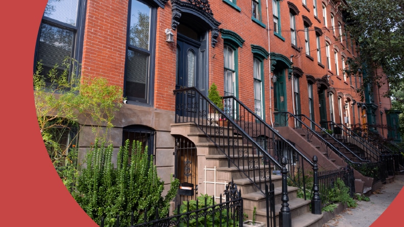A row of old brick homes with staircases along a sidewalk in Hamilton Park of Jersey City.