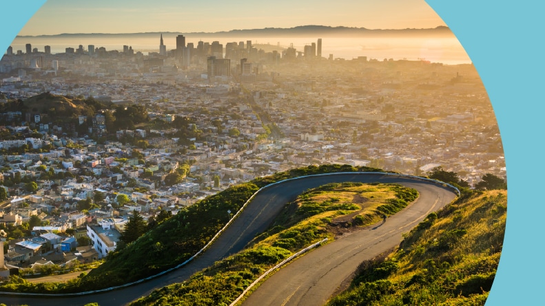 Aerial view of a curvy road and Downtown San Francisco at sunrise from Twin Peaks in California.