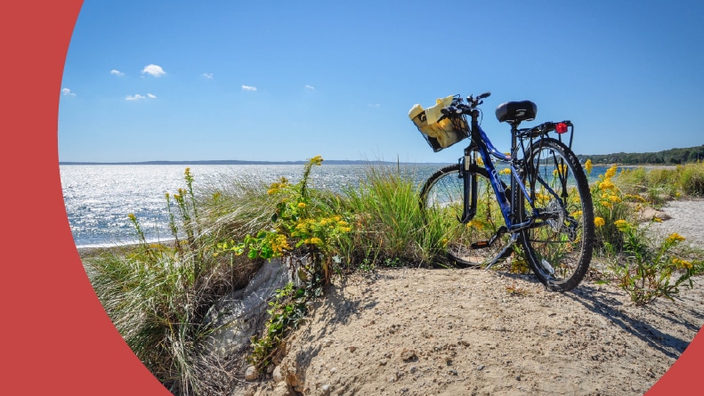 A parked bicycle with a basket on a beach bike path in Cape Cod, Massachusetts.