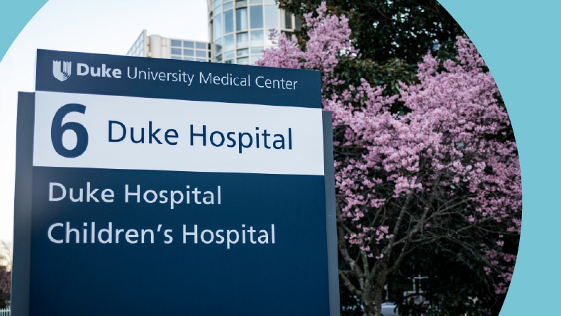 Duke University Hospital and Children's Hospital sign beside cherry blossoms.