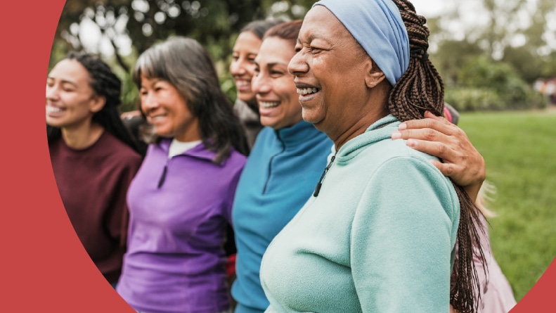 A happy group of 55+ women smiling outside.