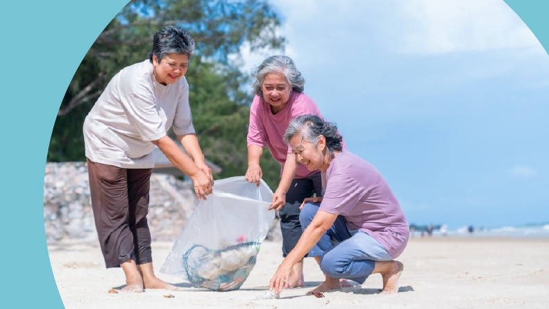 A group of 55+ women volunteers picking up plastic trash and garbage at the beach.