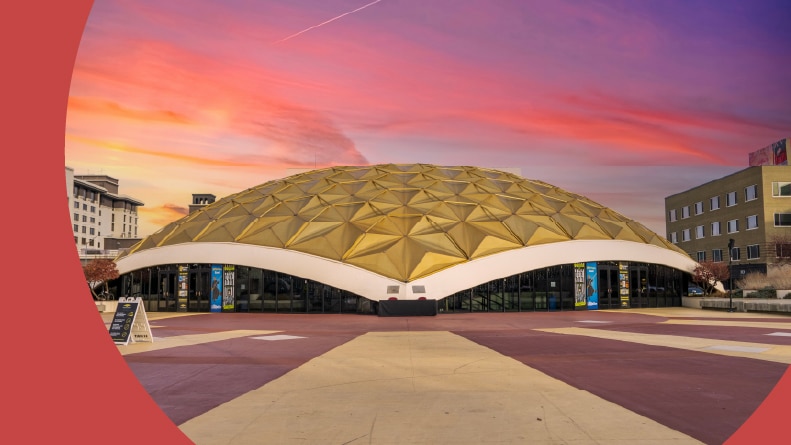 The Pioneer Center for the Performing Arts with office buildings, autumn trees and green grass at sunset in Reno, Nevada.