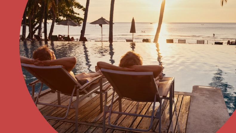 A retired couple in lounge chairs beside a pool in a resort-style 55+ community.