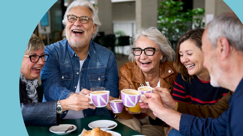 A group of retired friends enjoying coffee and pastries at a cafe in their 55+ community.
