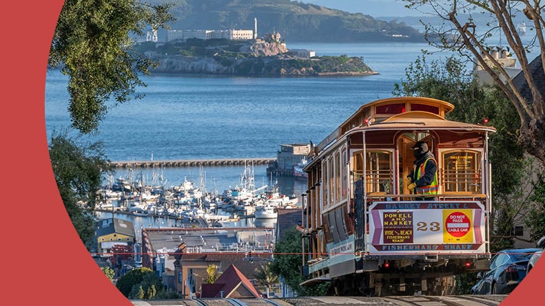 A cable car moving down a hill in San Francisco, California.