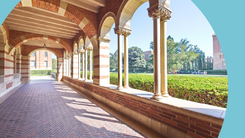 A corridor with stone pillars at UCLA on a sunny day.