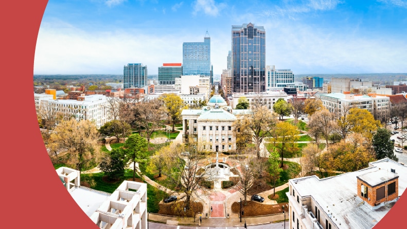 Aerial view of the North Carolina State Capitol and Raleigh skyline.