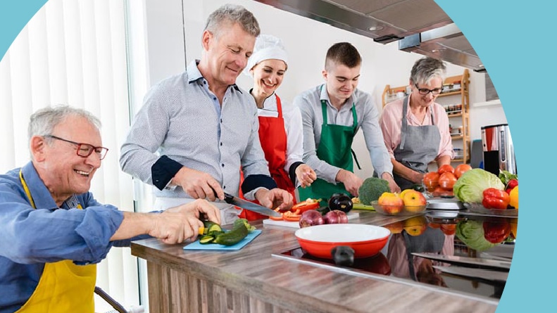 A group of 55+ active adults taking a cooking class.