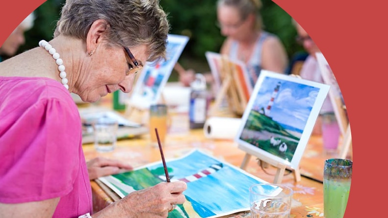 A senior woman in a painting class in her 55+ community.
