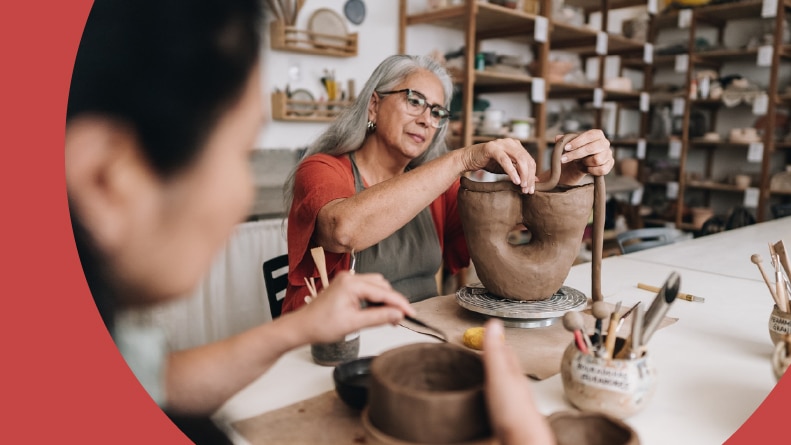 An active adult woman making pottery in a class in a 55+ community.