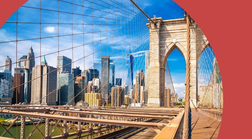 View of Manhattan from the Brooklyn Bridge in New York City on a sunny day.