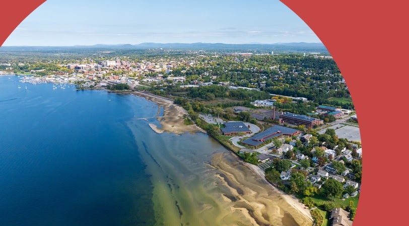Aerial view of Burlington, Vermont with Lake Champlain's blue waters and marina stretching into the distance.