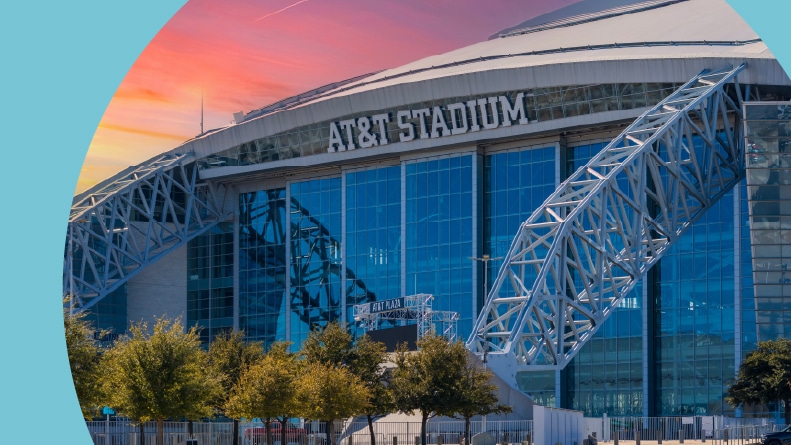 AT&T Stadium surrounded by trees and plants at sunset in Arlington, Texas.