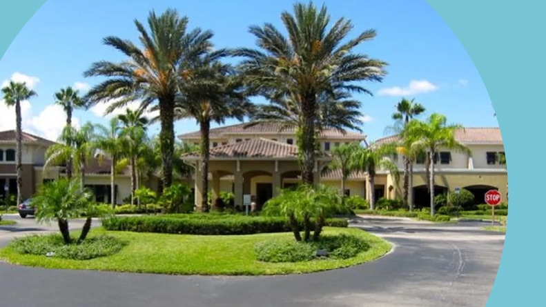 Palm trees beside the entrance to the clubhouse at Kings Point in Sun City Center, Florida.