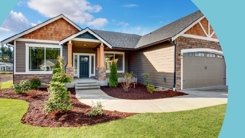 A large modern house with a walkway and lots of grass.