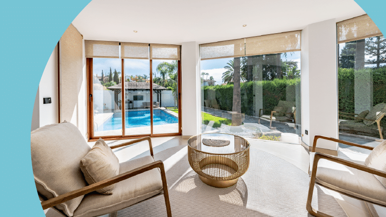 A luxury villa with windows overlooking the private swimming pool in the garden.