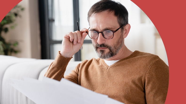 An active adult man carefully reading the HOA rules of his 55+ community.