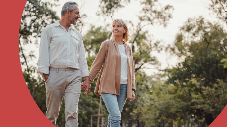 An active adult couple holding hands while touring a 55+ community.
