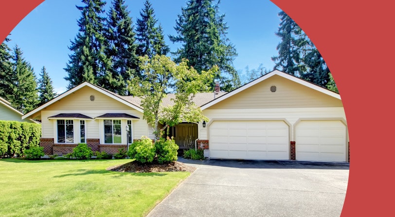 A single-story ranch-style home with a three-car garage, brick accents, and a manicured lawn framed by tall evergreen trees.