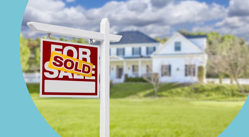 A red "For Sale" real estate sign with a yellow "Sold" banner stands in the front lawn of a two-story white house.