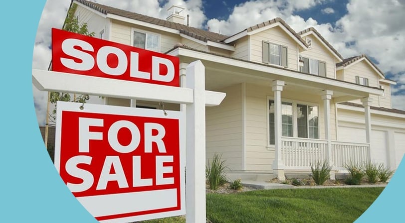 A sold and for-sale sign in front of a newly purchased single-family home.