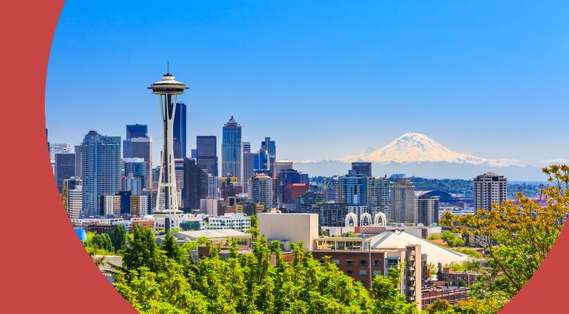 The Seattle skyline with the Space Needle in the foreground and snow-covered Mount Rainier on the horizon.