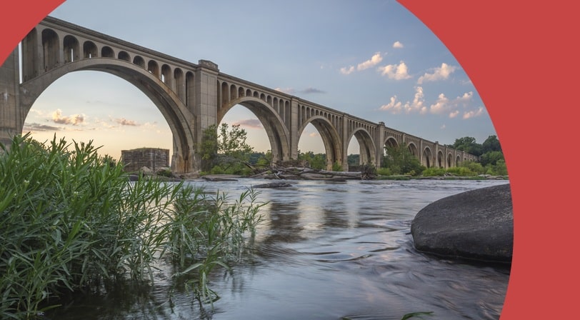 A concrete arch railroad bridge spanning the James River.