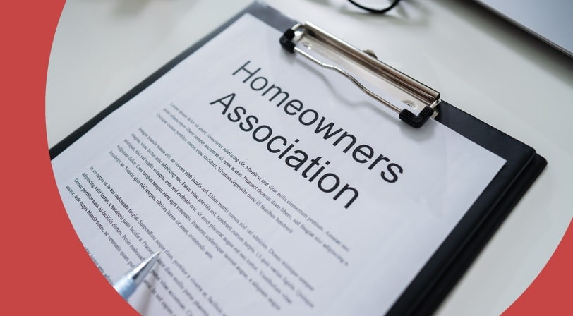 A homeowners association document on a clipboard being reviewed with a pen, representing the HOA guidelines common in 55+ communities.