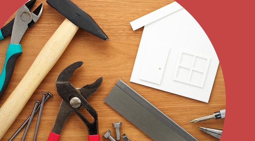 Tools laying around a white cutout of a house.