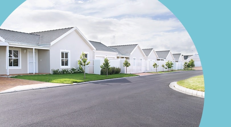 A row of matching single-story homes with tiled roofs along a quiet suburban street.