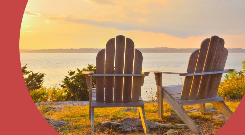 Adirondack chairs on cliff overlooking the water Narragansett Bay at sunset.