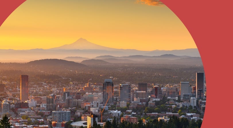 The Portland skyline at sunrise with Mount Hood silhouetted on the horizon.