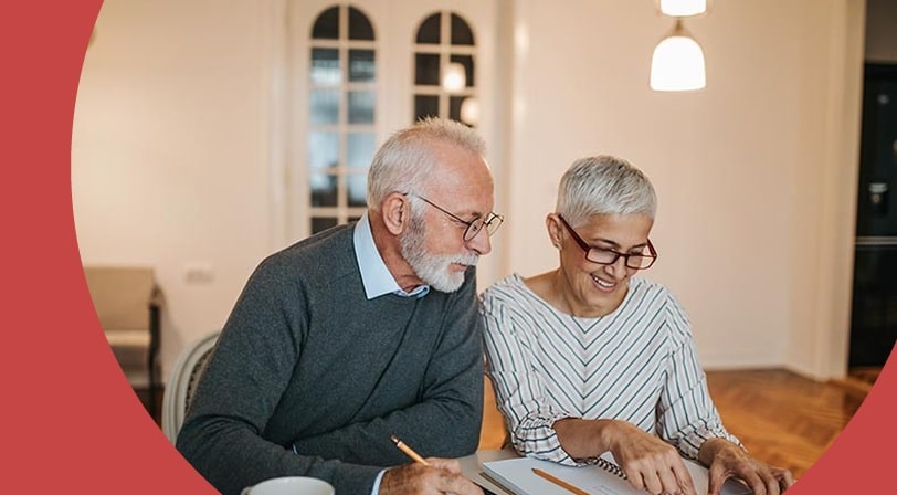 A 55+ couple calculating how much money they'll save by downsizing their house.