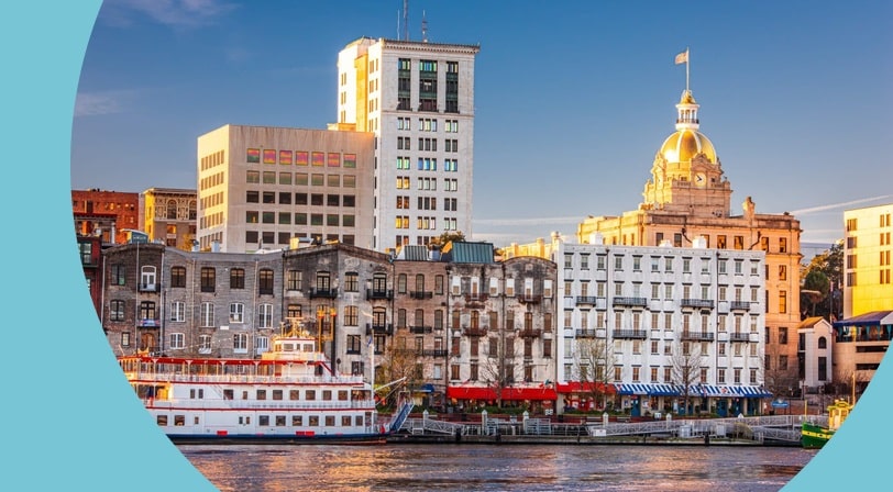 The riverfront skyline of Savannah, Georgia with a paddle wheel boat.