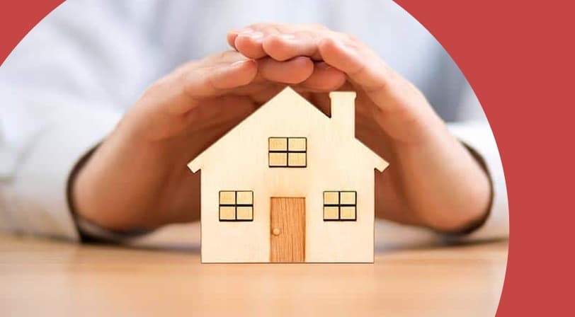 Hands covering a wood model house.
