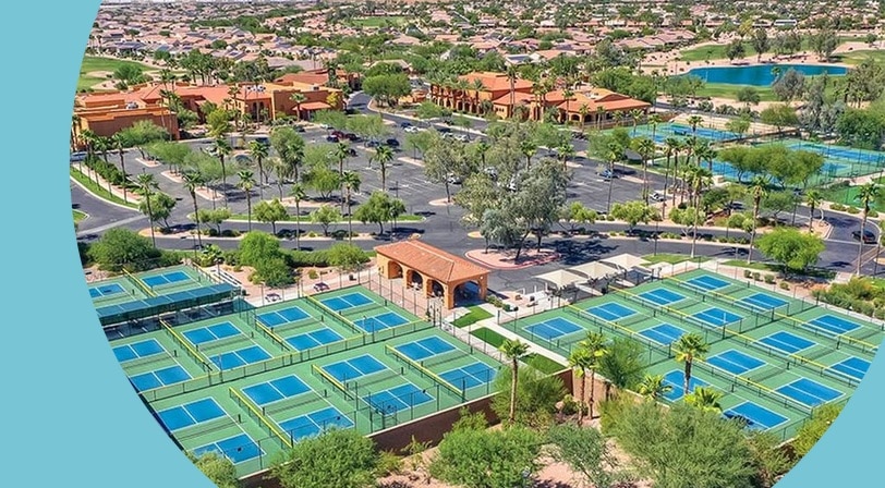 Aerial view of the clubhouse, pickleball courts, and tennis courts at PebbleCreek, a 55+ community in Goodyear, Arizona.