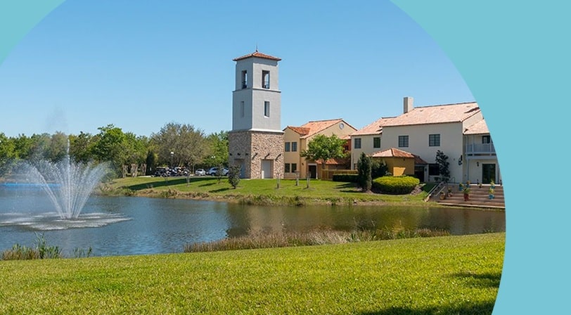 Lakefront clubhouse with bell tower at Solivita, a 55+ community in Kissimmee, Florida.