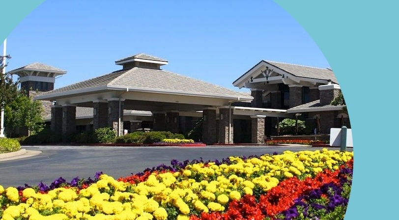 Clubhouse and pool with mountain backdrop at Sun City Roseville, a 55+ community in Roseville, California.