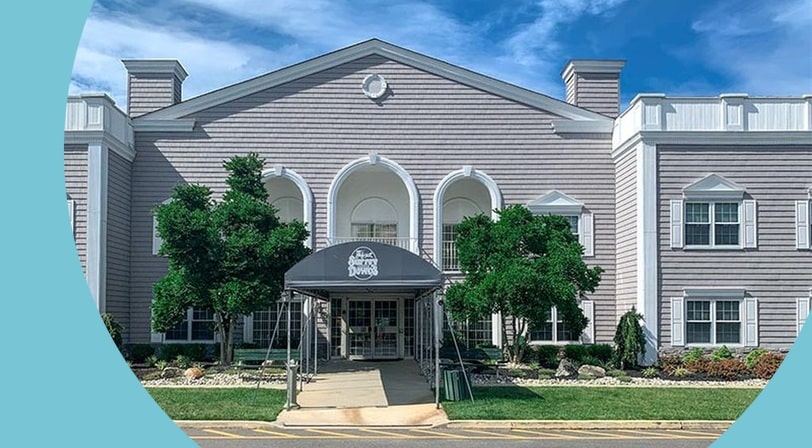 Clubhouse entrance with covered walkway at Surrey Downs, a 55+ community in Freehold, New Jersey.
